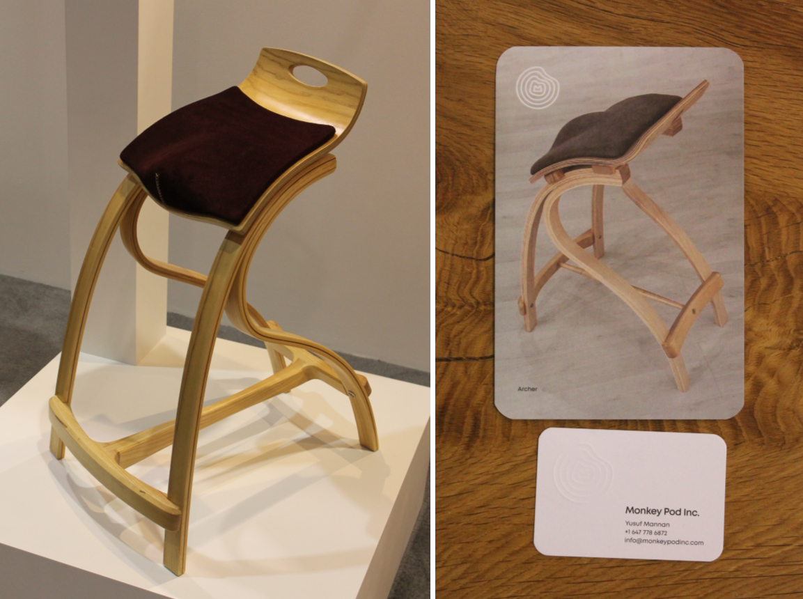 A standing chair made of light coloured wood, with a dark brown seat cushion.