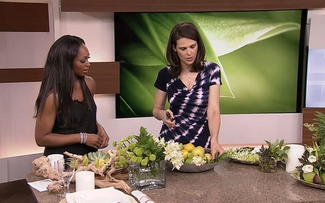 Celia Alida Rutte and Tracy Moore on the Cityline set showing viewers how to add greenery to a bowl of fruit.